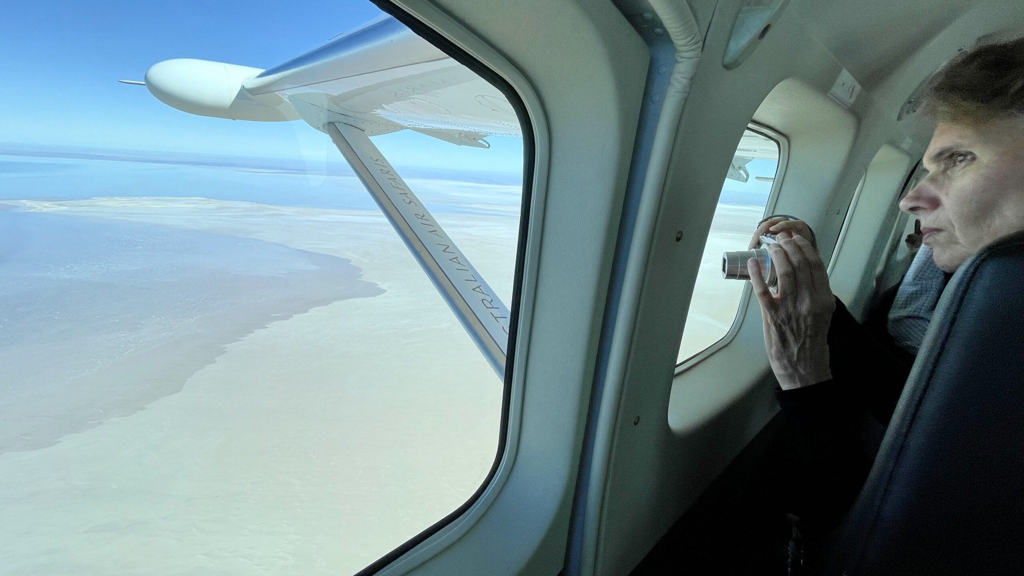 Guest looking out over Lake Eyre from aeroplane